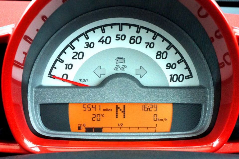 Detailed view of a car's speedometer and digital dashboard display with various indicators.